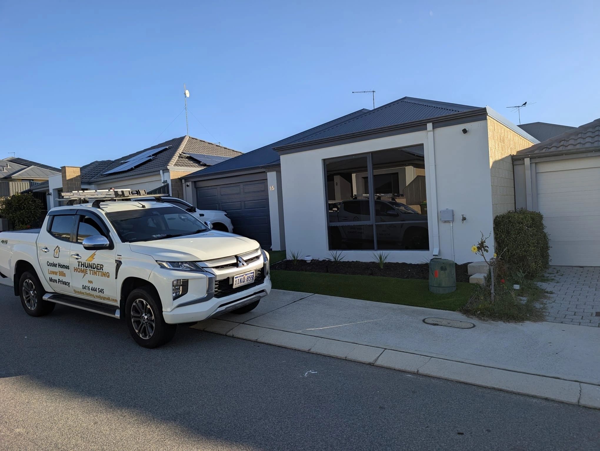 Thunder Home Tinting's branded vehicle outside a home with tinted windows